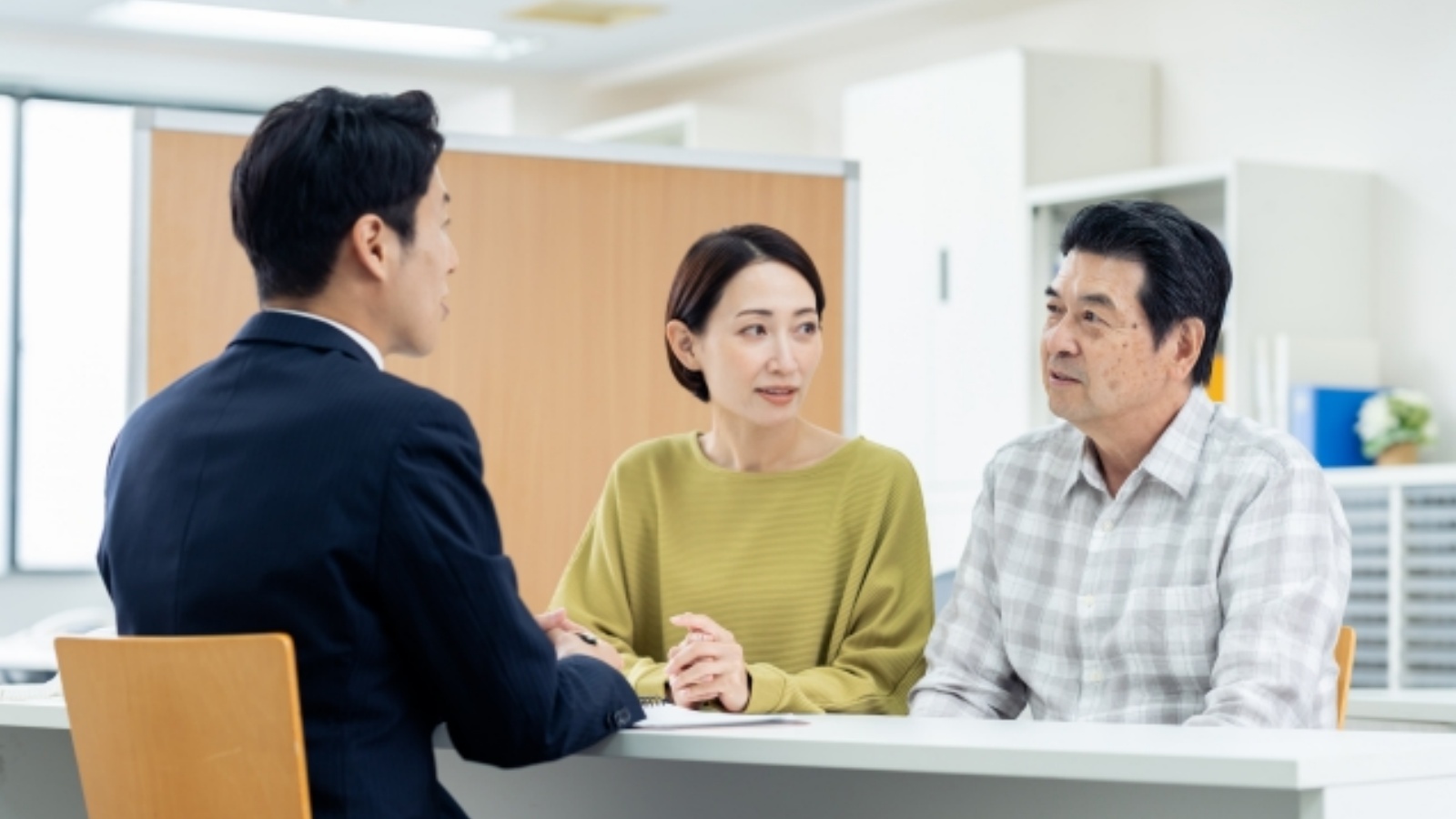住宅ローン一本化プランを夫婦が担当者と打ち合わせる場面