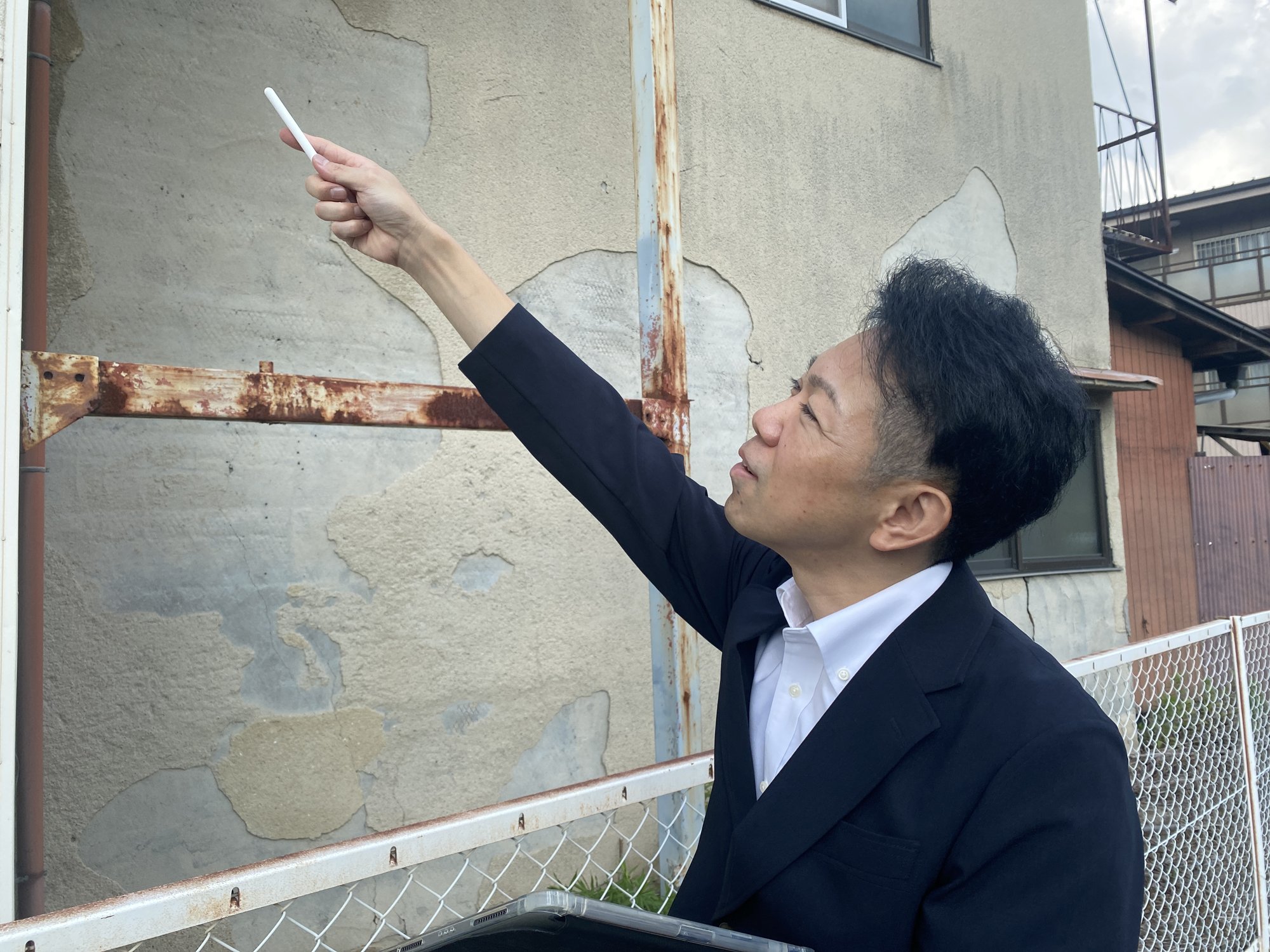 外壁のひび割れ・劣化状況を確認する現地調査の様子